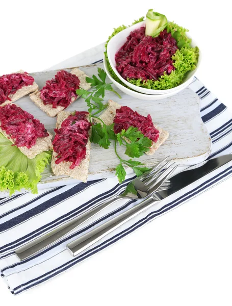 Beet salad on toasts and in plates on board on napkin isolated on white — Stock Photo, Image