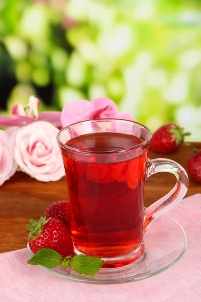 Delicious strawberry tea on table on bright background — Stock Photo, Image