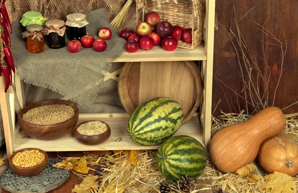 Fruits and vegetables with jars of jam and bowls of grains on shelves close up — Stock Photo, Image