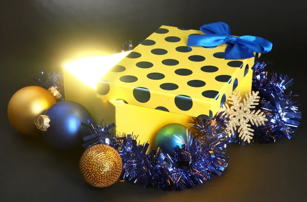 Caja de regalo con luz brillante sobre fondo gris oscuro — Foto de Stock