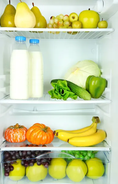 Botellas de leche, verduras y frutas en nevera abierta. concepto de dieta de pérdida de peso . — Foto de Stock