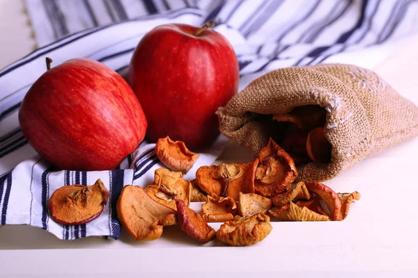 Dried apples and fresh apples, on white wooden background