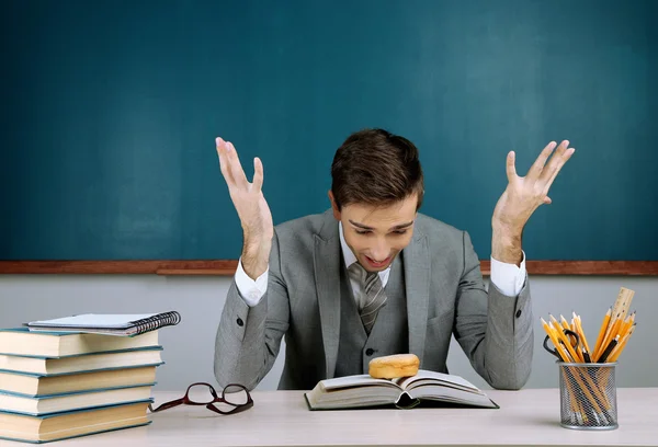 Junge Lehrerin sitzt im Klassenzimmer — Stockfoto