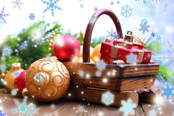 Composition avec décorations de Noël dans le panier, sapin sur table en bois, sur fond clair — Photo