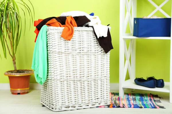 Cesta de lavandaria completa no chão de madeira em casa fundo interior — Fotografia de Stock