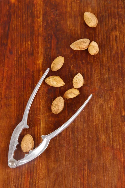 Notenkraker met noten op houten tafel close-up — Stockfoto