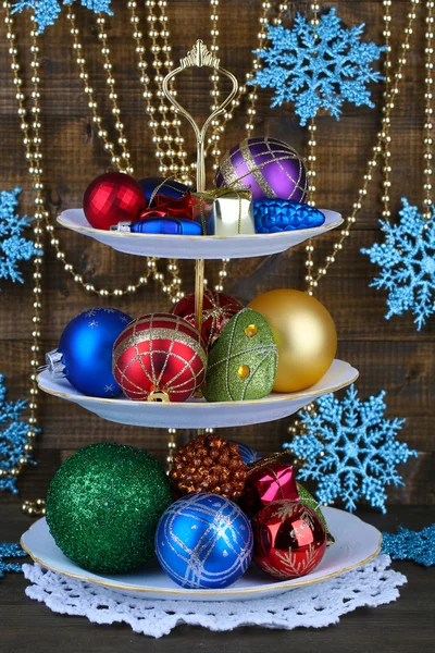 Christmas decorations on dessert stand, on color wooden background — Stock Photo, Image