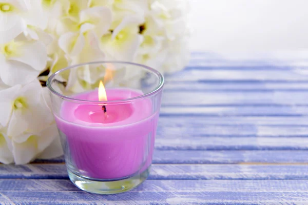 Hermosas velas de colores y flores, sobre fondo de madera de color — Foto de Stock