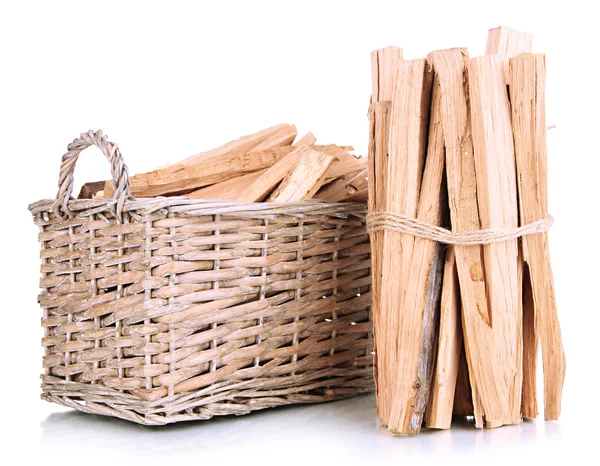 Stapel brandhout in rieten mand geïsoleerd op wit — Stockfoto