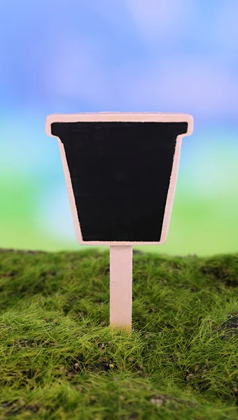Small chalk board on grass on light background — Stock Photo, Image
