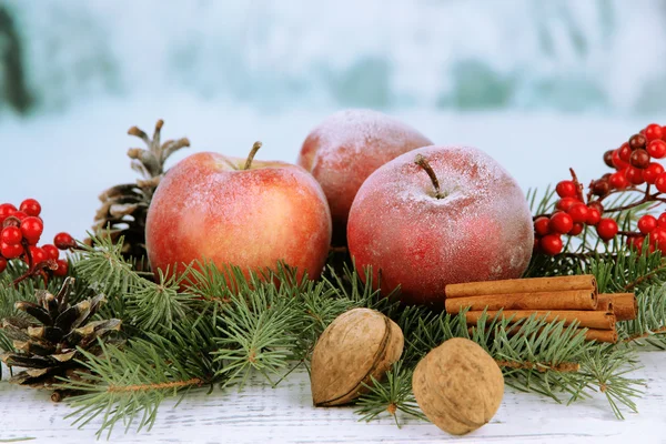 Weihnachtskomposition mit roten Winteräpfeln auf hellem Hintergrund — Stockfoto