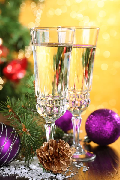 Composition with Christmas decorations and two champagne glasses, on bright background — Stock Photo, Image