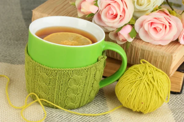 La taza del té con la cosa tejida en él se acercan —  Fotos de Stock