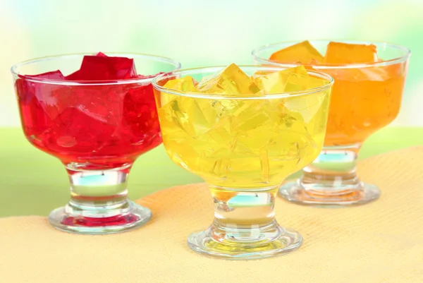 Tasty jelly cubes in bowls on table on light background — Stock Photo, Image