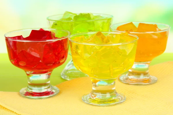 Tasty jelly cubes in bowls on table on light background — Stock Photo, Image
