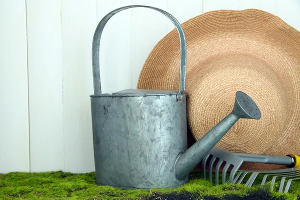 Gartengeräte auf Gras auf Holzgrund — Stockfoto