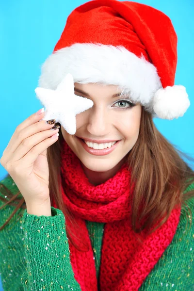 Vackra leende flicka med jul snöflinga på blå bakgrund — Stockfoto