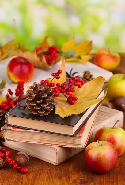 Livres et feuilles d'automne sur table en bois sur fond naturel — Photo