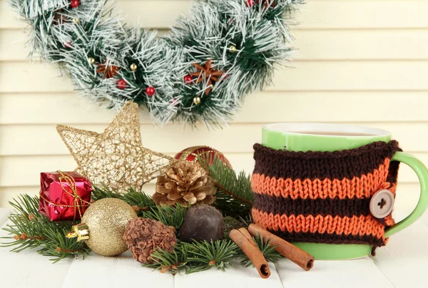 Tazza di cioccolata calda con cioccolatini e addobbi natalizi su tavola su fondo di legno — Foto Stock