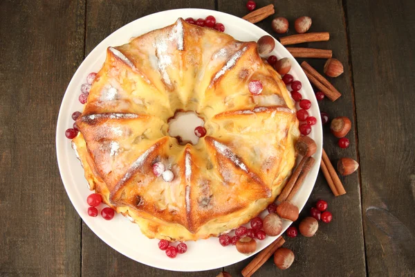 Schmackhafter hausgemachter Kuchen mit Beeren, Nüssen und Gewürzen, auf Holztisch — Stockfoto