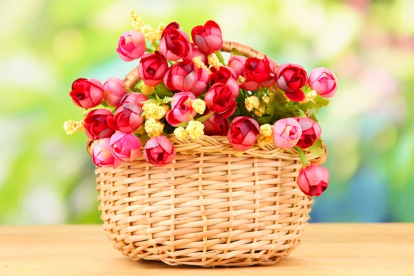 Μπουκέτο από όμορφα τεχνητά λουλούδια καλάθι, στο ξύλινο τραπέζι — Φωτογραφία Αρχείου