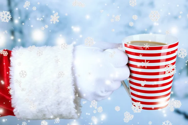 Santa segurando caneca em sua mão, no fundo claro — Fotografia de Stock