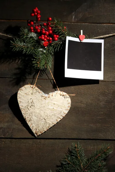 Dekorativní srdce a prázdné fotografický papír na lano, na dřevěné pozadí — Stock fotografie