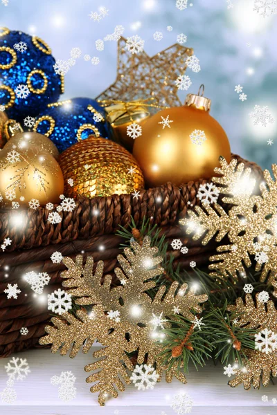 圣诞装饰品在篮子和云杉枝上明亮的背景表格 — 图库照片