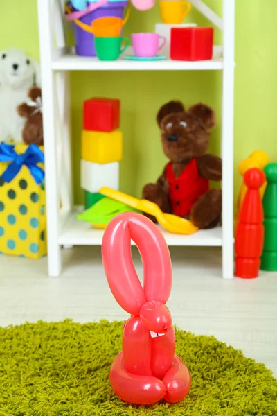 Simple balloon animals and other toys on shelves, on bright background — Stock Photo, Image