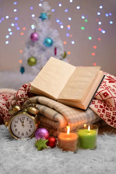 Composition avec plaids, bougies et décorations de Noël, sur tapis blanc sur fond lumineux — Photo