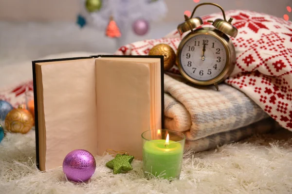 Composition with plaids, candles and Christmas decorations, on white carpet on bright background — Stock Photo, Image