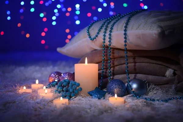 Composition with plaids, candles and Christmas decorations, on white carpet on bright background — Stock Photo, Image