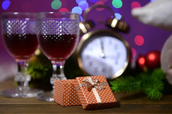 Wine glasses, retro alarm clock and Christmas decoration on bright background — Stock Photo, Image