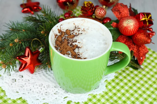 Chocolate quente com creme na caneca de cor, no guardanapo, no fundo de decorações de Natal — Fotografia de Stock