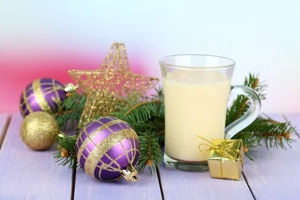 Copa de ponche de huevo con ramas de abeto y decoraciones de Navidad en la mesa sobre fondo brillante — Foto de Stock