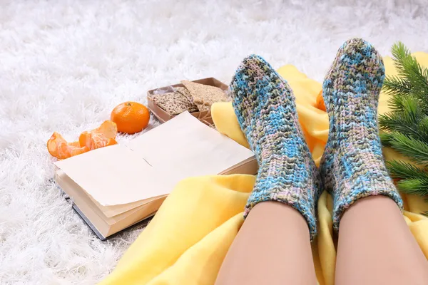 Composición con cuadros calientes, libro, k y piernas femeninas, sobre fondo de alfombra de color — Foto de Stock