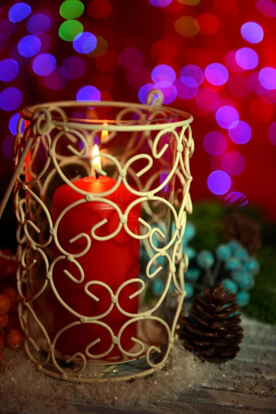 Vela e broto de árvore de Natal na mesa de madeira no fundo brilhante — Fotografia de Stock