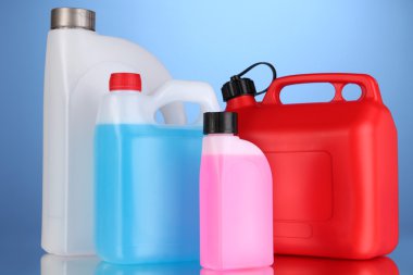 Liquids for car in canisters on blue background clipart