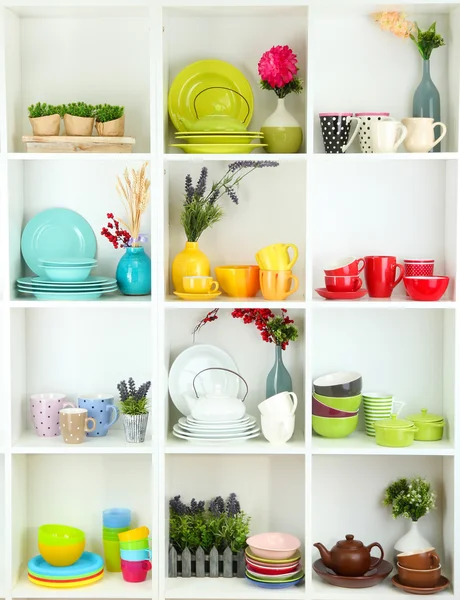 Beautiful white shelves with tableware and deco — Stock Photo, Image
