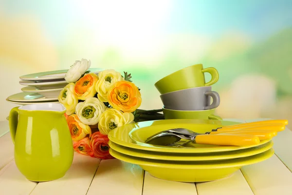 Lots beautiful dishes on wooden table on natural background — Stock Photo, Image