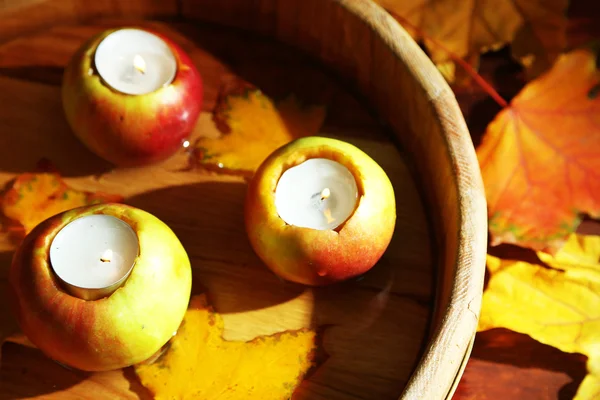 Composição com maçãs e velas em banheira sobre fundo de madeira — Fotografia de Stock