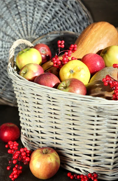 Saftige Äpfel und Kürbis im Holzkorb auf dem Tisch in Großaufnahme — Stockfoto