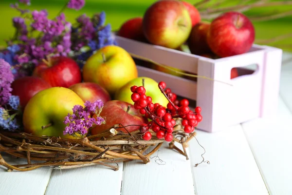 Сочные яблоки в коробке на белом деревянном столе — стоковое фото