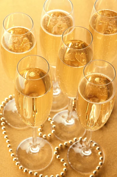 Bicchieri con champagne su sfondo lucido — Foto Stock