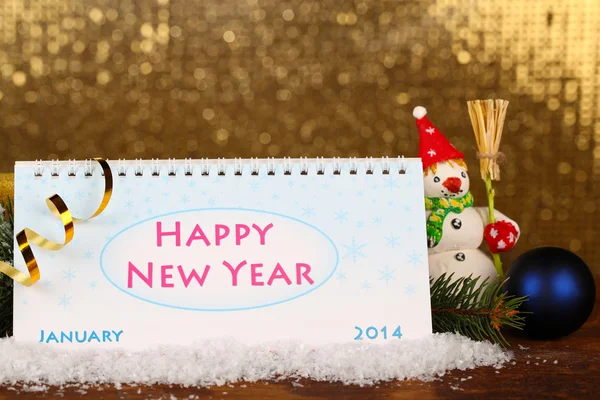 Calendário, decoração de Ano Novo e abeto em fundo dourado brilhante — Fotografia de Stock