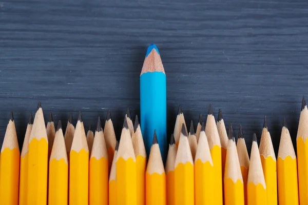 Celebratory pencil among usual pencils, on color background — Stock Photo, Image