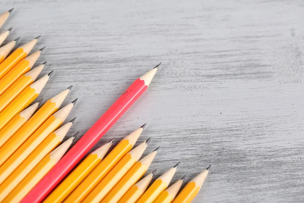 Celebratory pencil among usual pencils, on color background — Stock Photo, Image