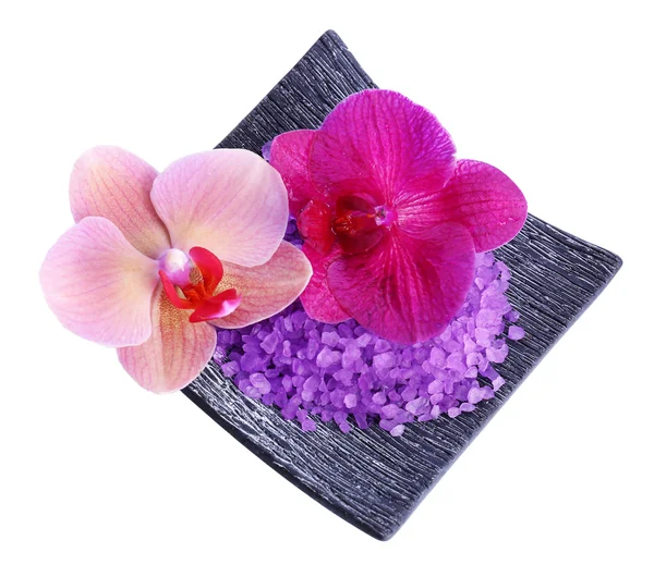 Beautiful blooming orchid flowers and heap of sea salt on plate, isolated on white — Stock Photo, Image