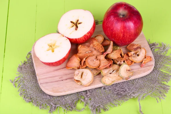 Gedroogde appels, op snijplank, op een houten achtergrond kleur — Stockfoto