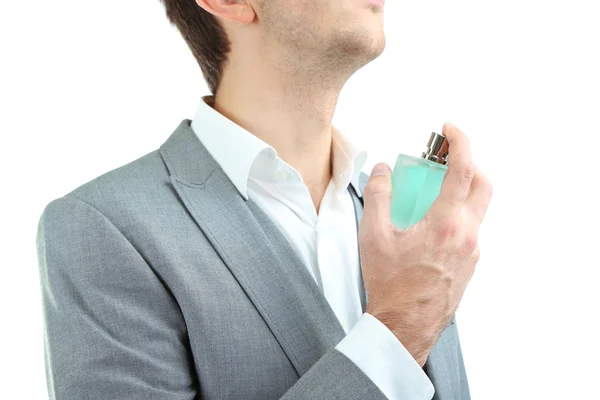 Bonito jovem usando perfume isolado no branco — Fotografia de Stock